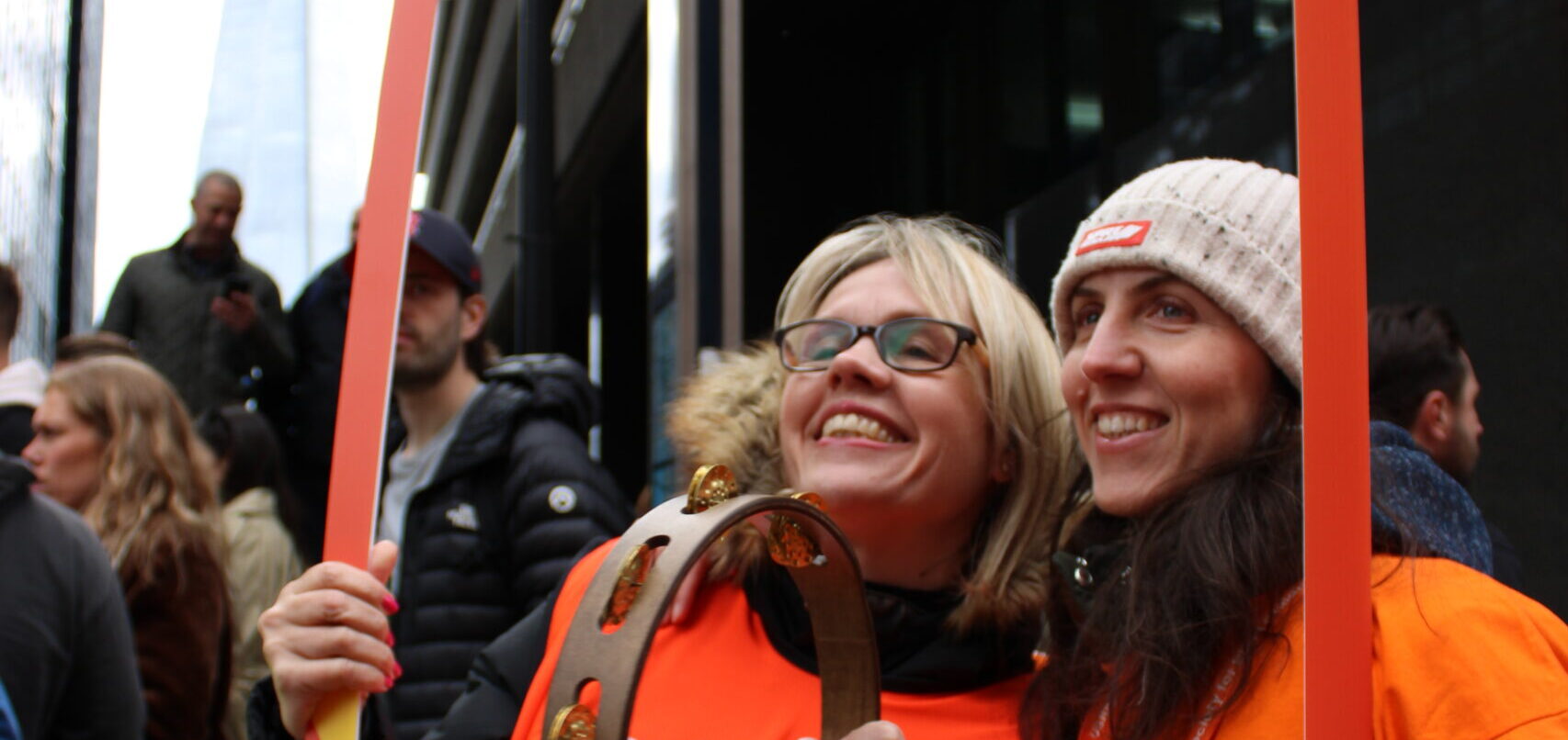 two people proudly cheering our runners at the London Marathon