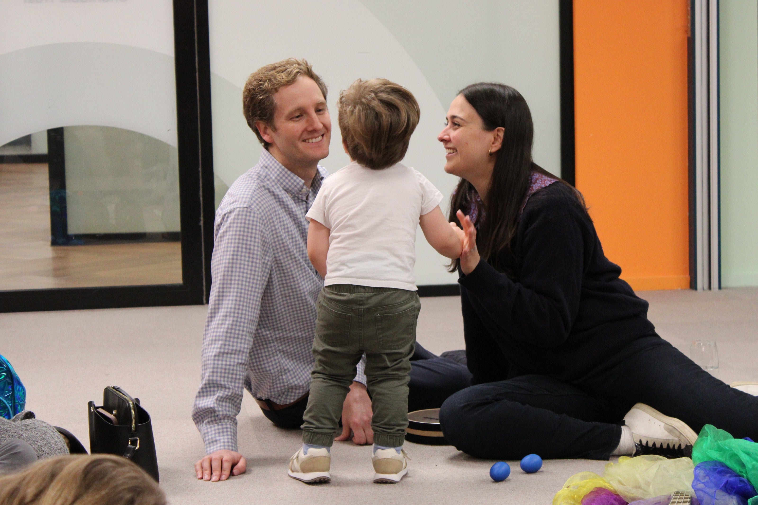 A mum and dad looking lovingly at their small child.