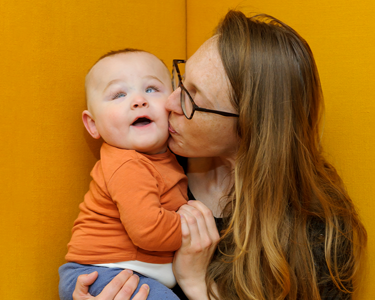 a mum giving her baby a loving kiss
