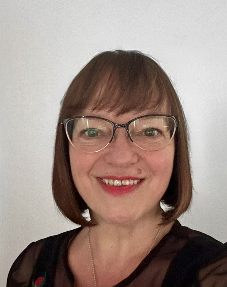 Woman smiling bright with glasses and a neutral background