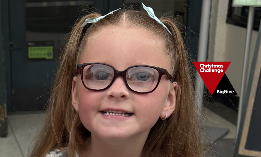 A young girl, Maya, with glasses looking at the camera, with 'Christmas Challenge BigGive' logo in the corner.