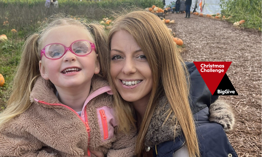 Mother and child, Sharn and Maya, posing together with a pumpkin patch in the background. The 'Christmas Challenge BigGive' logo sits to the right side of Sharn the mother.