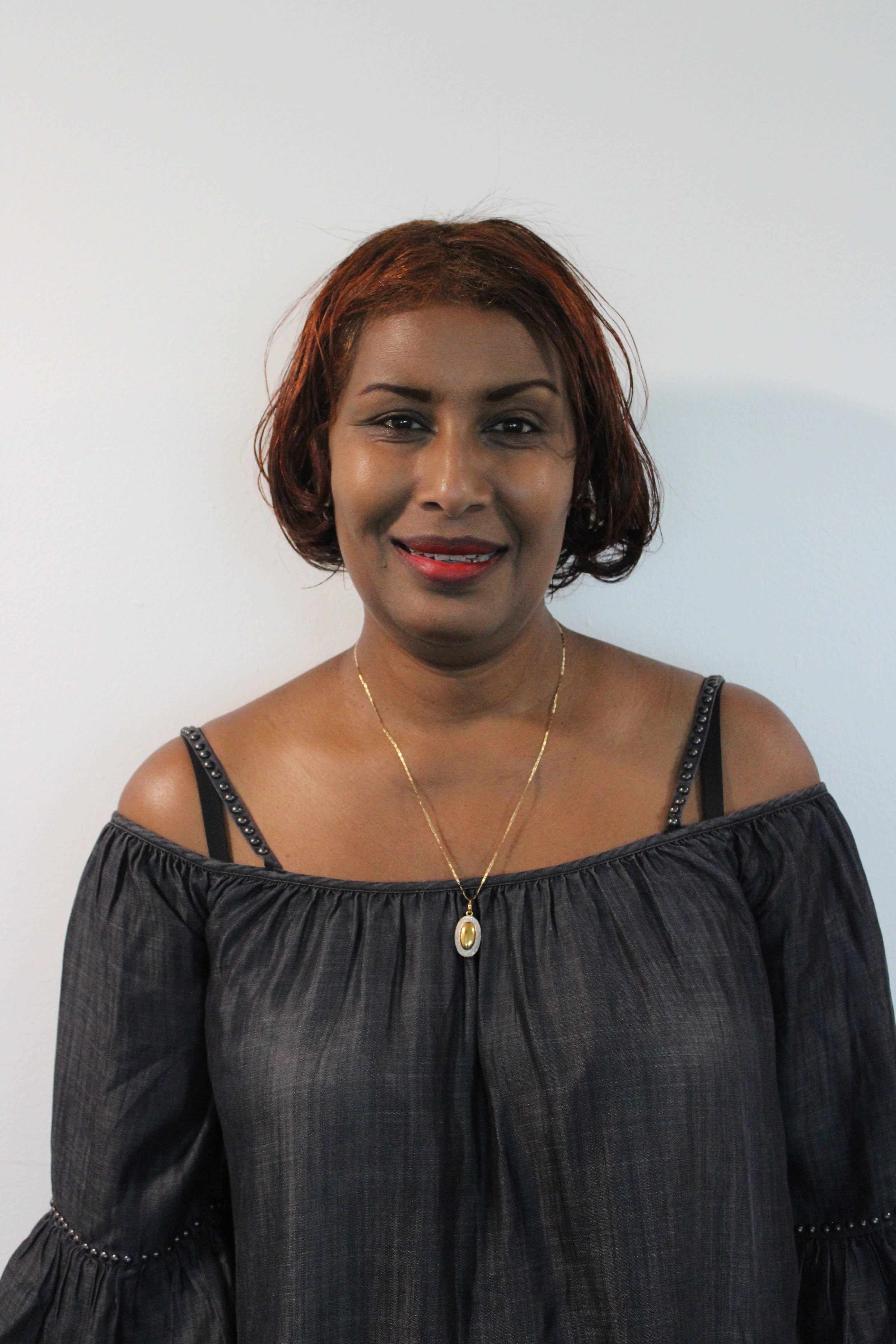 Elizabeth, a woman wearing a black top with thin straps against a white background