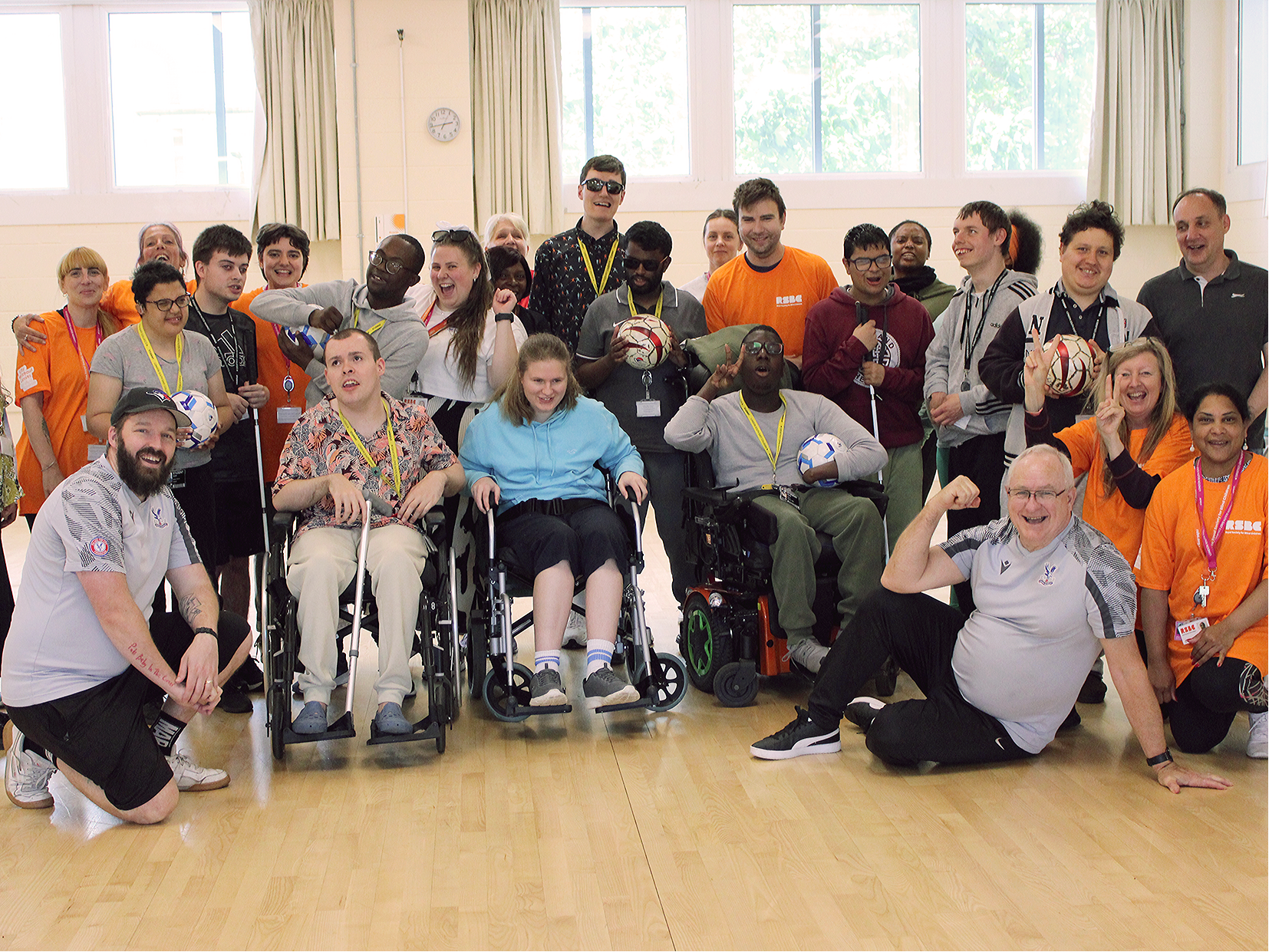 Group of people with and without disabilities posing together indoors.
