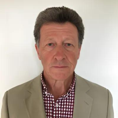 A man in a khaki blazer and red and white check shirt