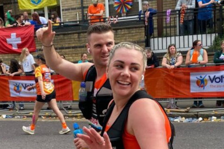 Runners participating in a race with spectators and flags in the background