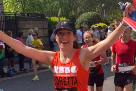 Woman in a marathon race with spectators and other runners in the background