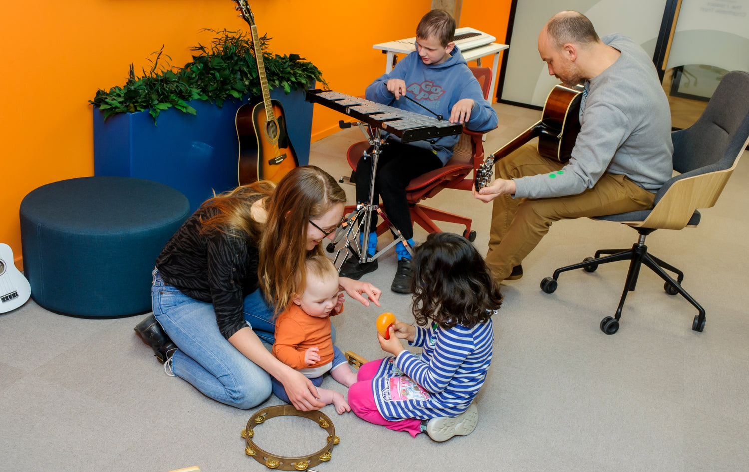 A mixed group of adults, young people and children playing musical instruments RSBC's Creative Suite.