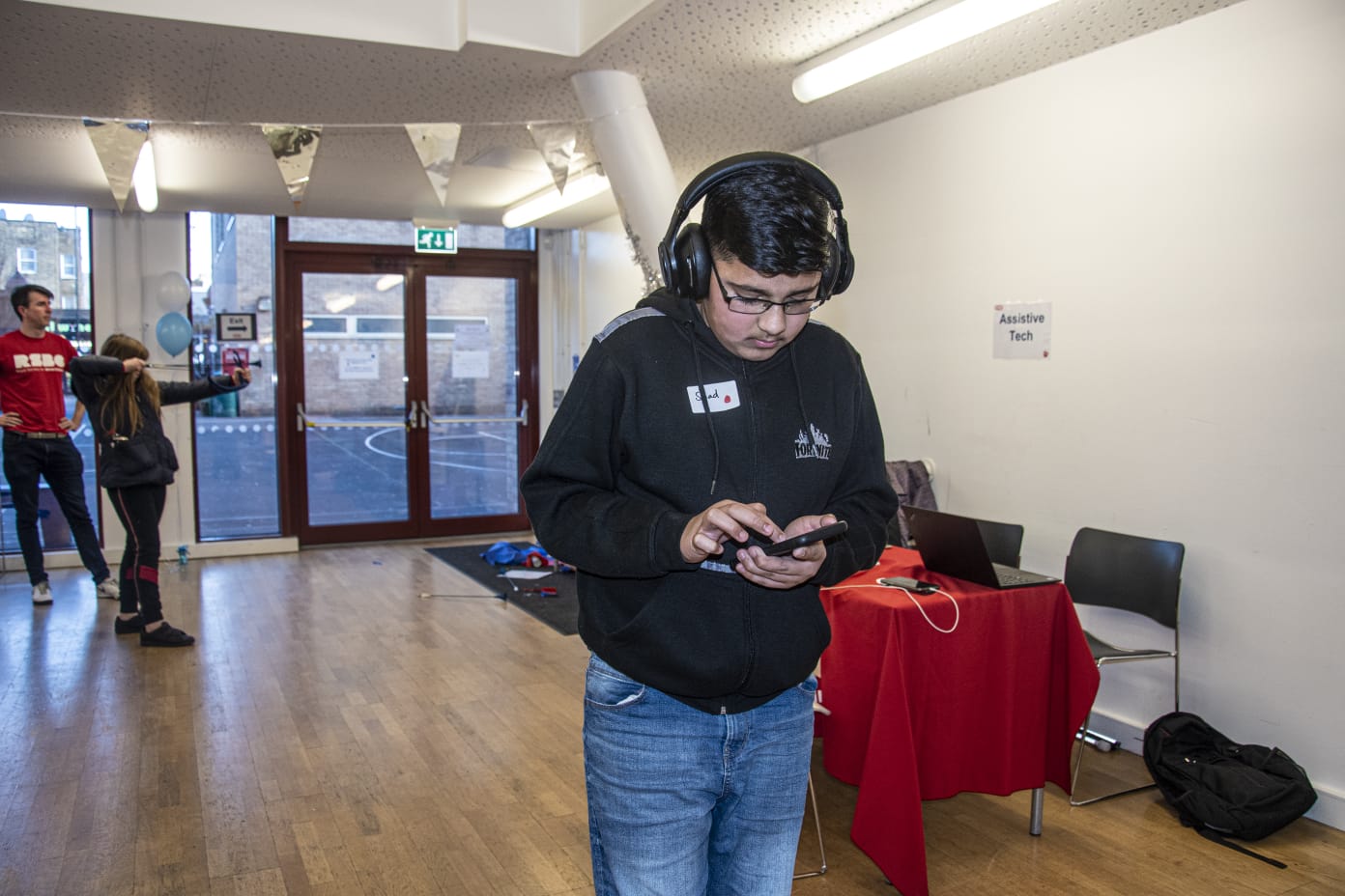 a boy using his phone with headphones on