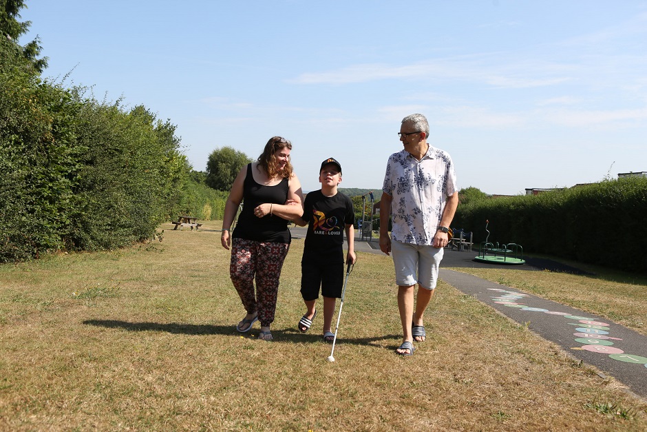 A picture of a boy walking with his parents