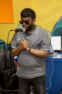 A young man is singing into a mic