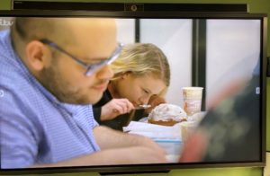 Two people cooking, viewed through a close up. 