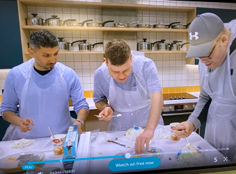 Three people cooking in a kitchen.