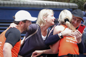 A RSBC runner hugging a group of 3 people