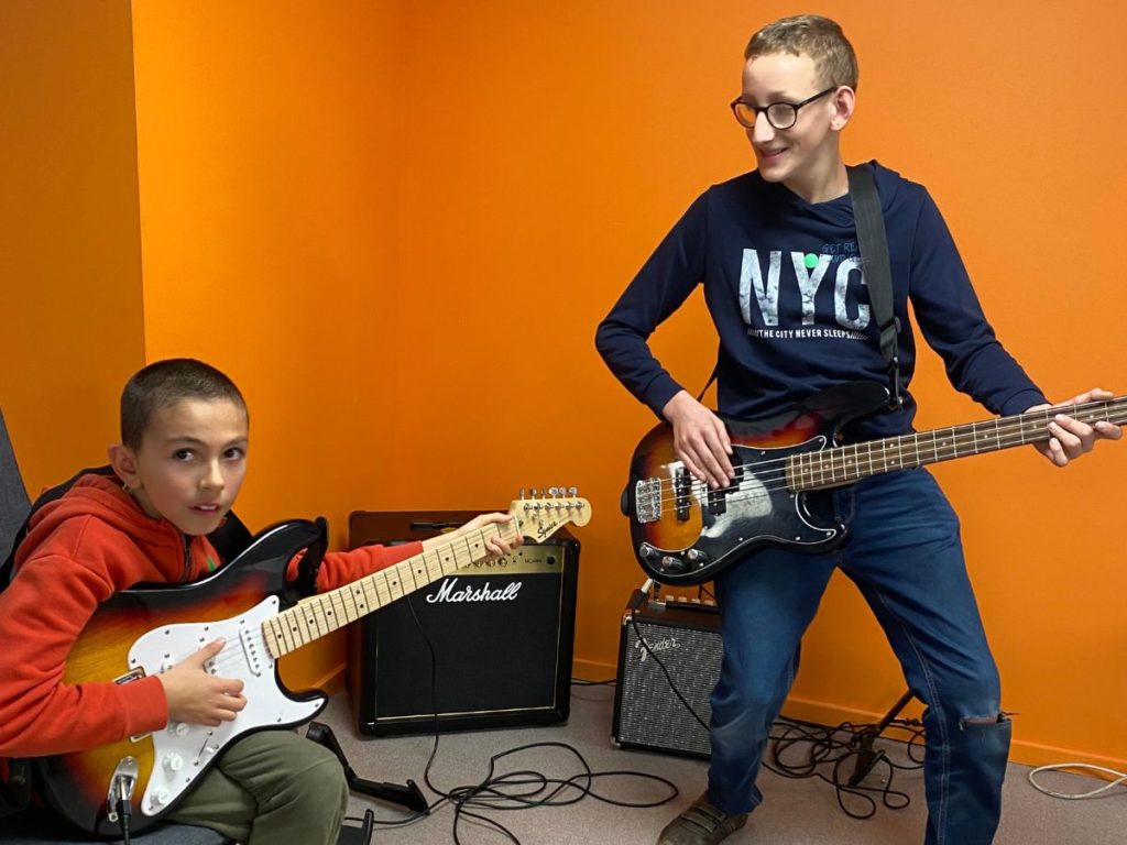 2 young boys playing electric guitar