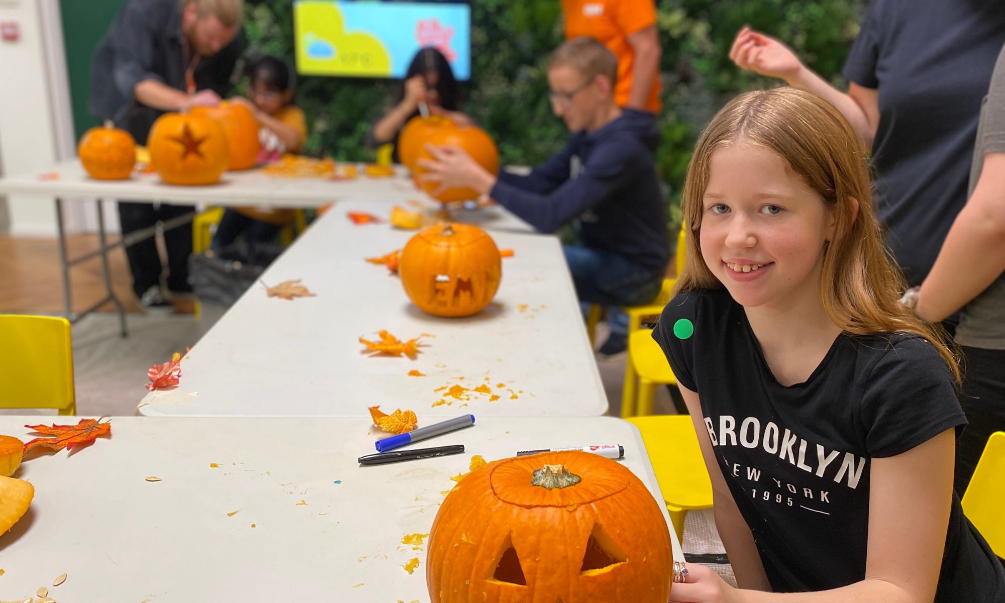 A girl smiling during a pumpkin carving activity