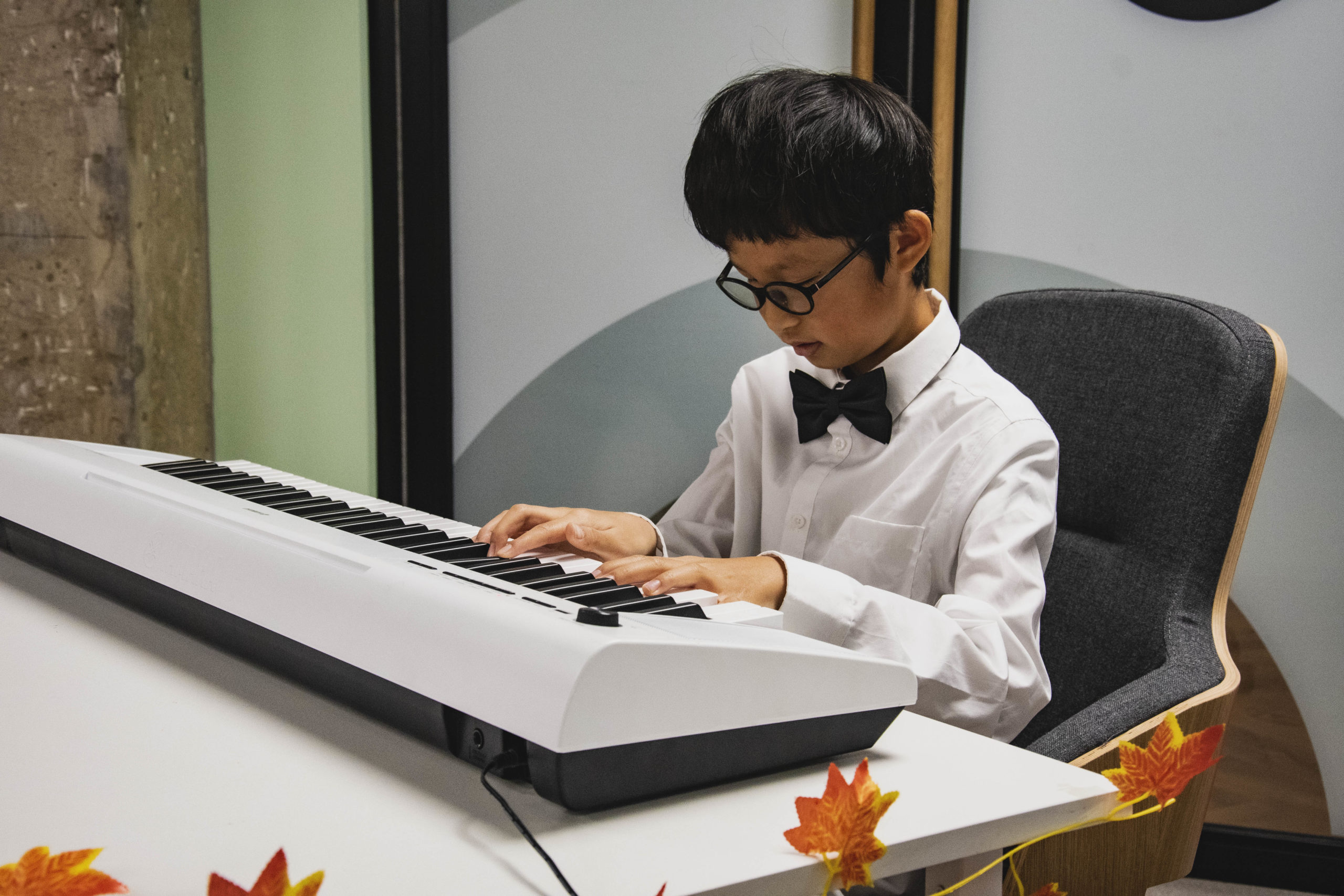 A young boy playing piano