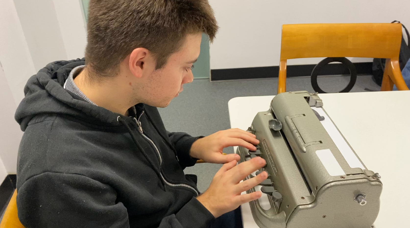 A Dorton College student typing on a Perkins Brailler