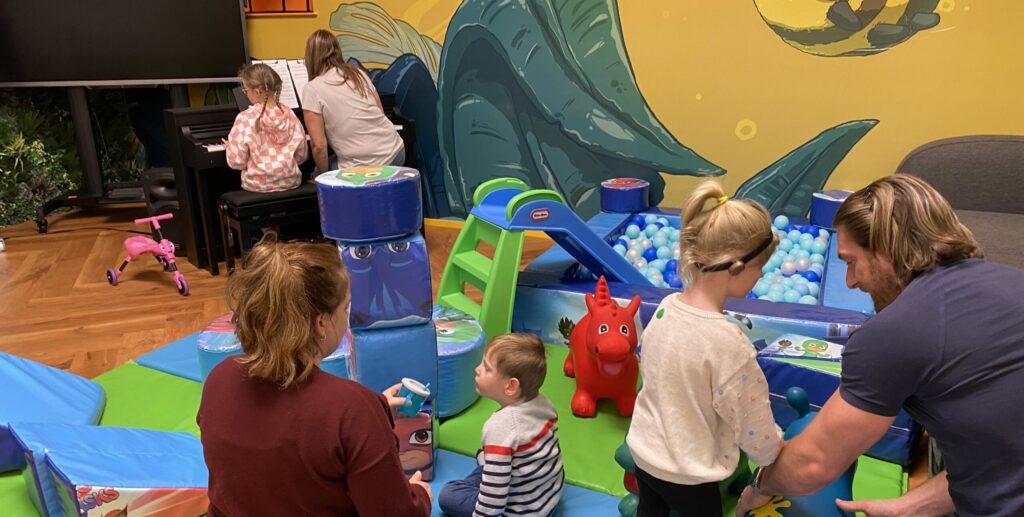 Families with blind partially sighted young children playing with sensory toys.