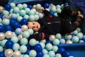 a child playing in a ball pit
