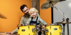 A dad with his son drumming