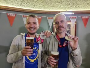 2 men showing their London Marathon medals