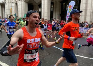 A man in the crowd wearing the RSBC orange vest with his mouth open