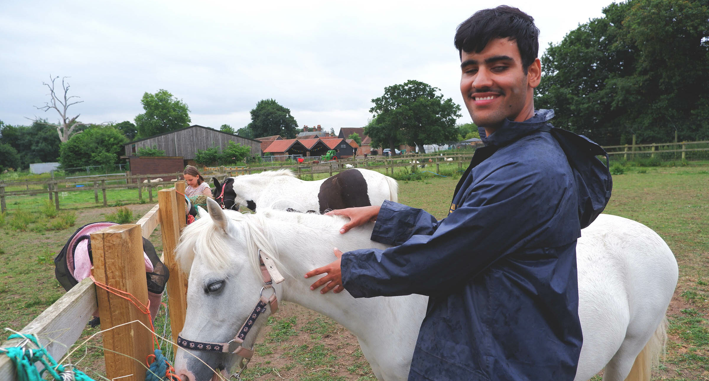 A young person smiling next to a horse
