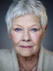 Headshot of a woman with short grey hair, blue eyes, looking at the camera.