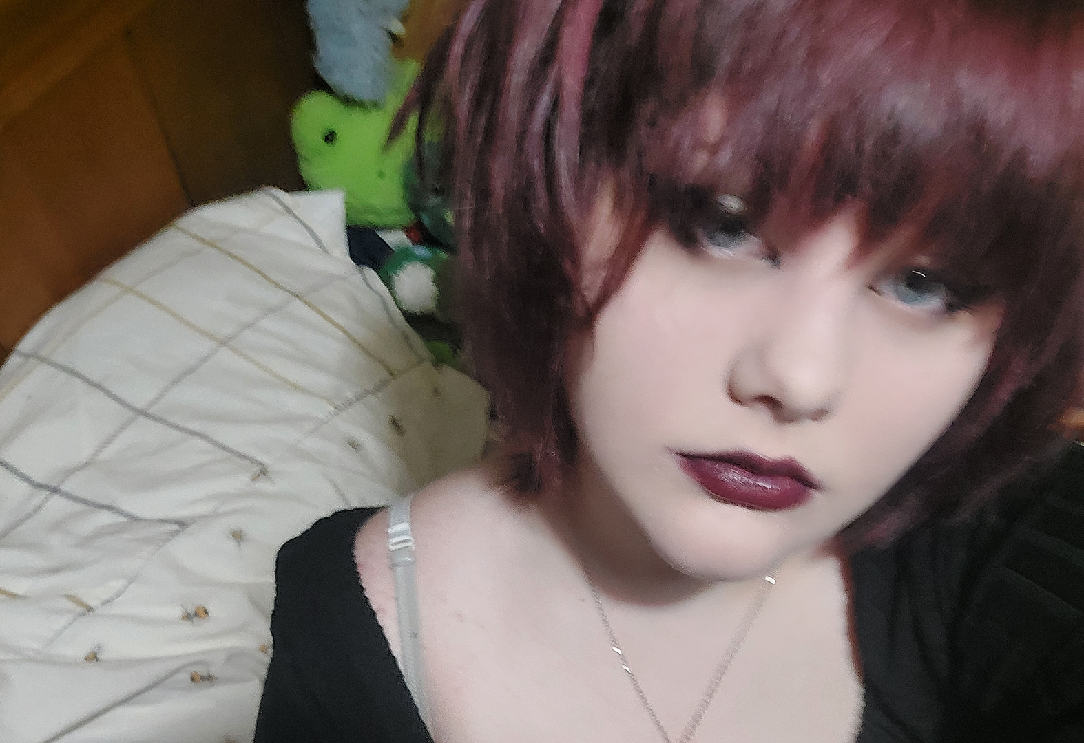 A selfie of teenage girl with short bobbed hair in her bedroom.